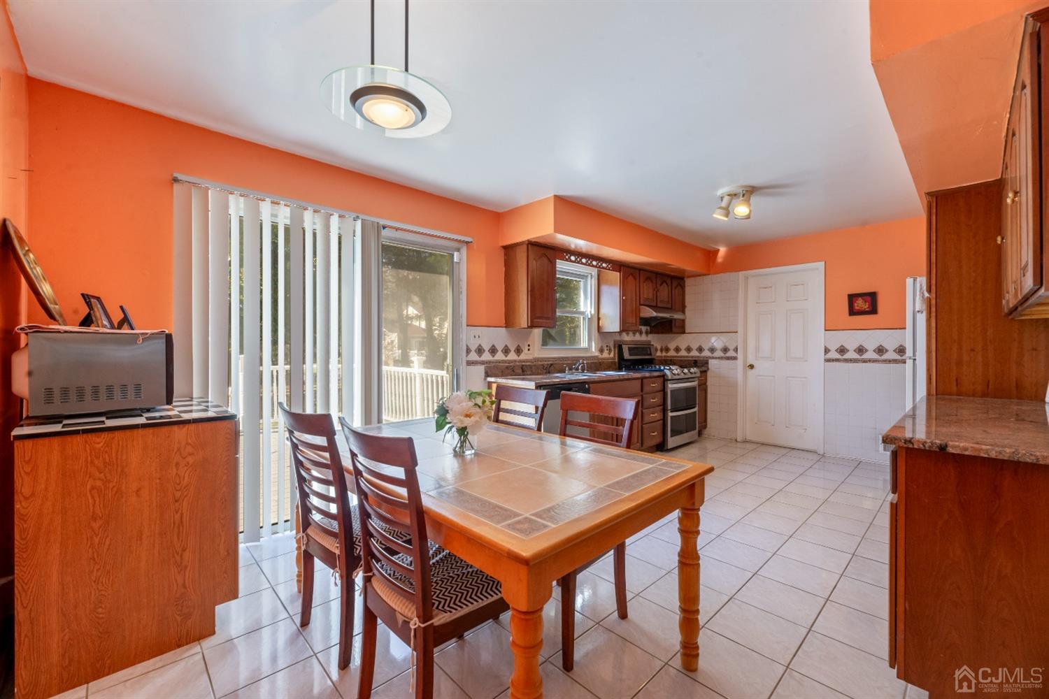 7 Prescott Road East Brunswick, NJ 08816 - Photo 9 of 30 a kitchen with stainless steel appliances granite countertop a stove a refrigerator a oven a sink with a dining table and chairs