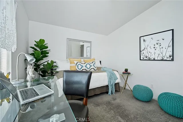 a bedroom with a bed and a potted plant