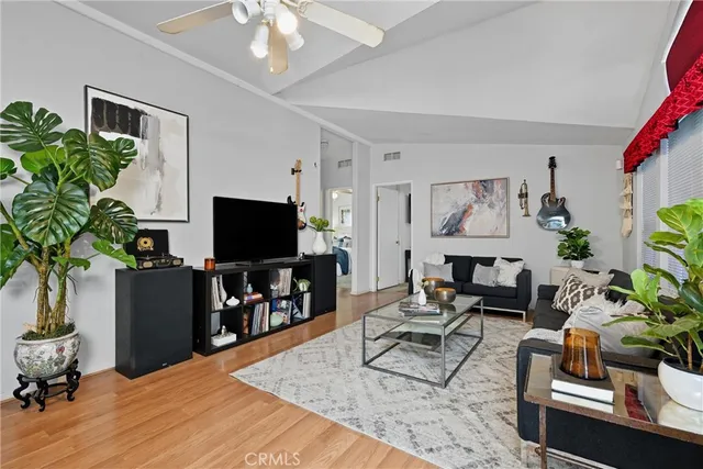 a living room with furniture potted plant and a flat screen tv