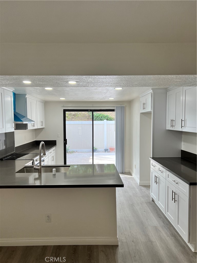 1409 Bodega Way, Unit 4 Diamond Bar, CA 91765 - Photo 6 of 15 a large kitchen with granite countertop a sink a stove and cabinets