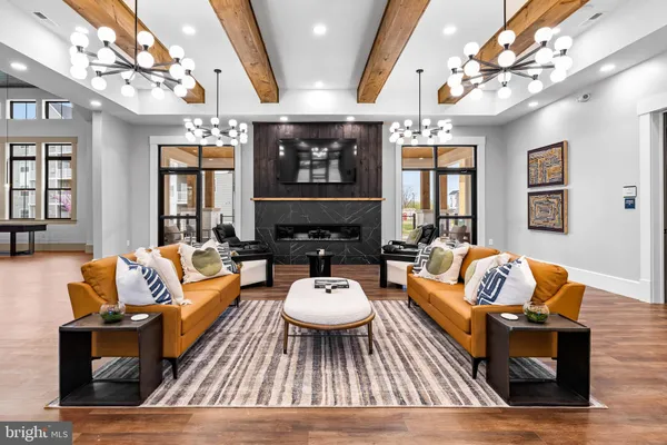 a living room with furniture a chandelier and a rug