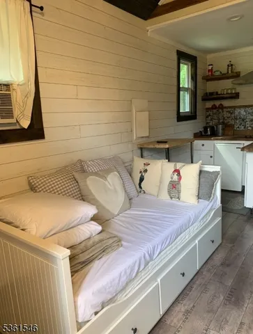 a bedroom with a bed a mirror and dresser