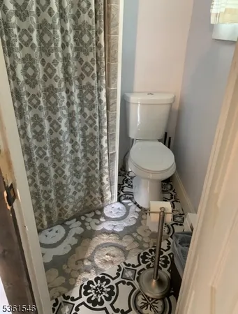 a bathroom with a toilet and a shower curtain