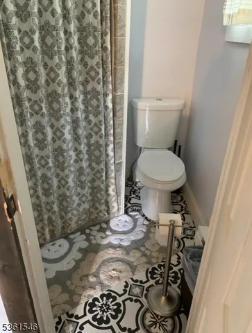 a bathroom with a toilet and a shower curtain
