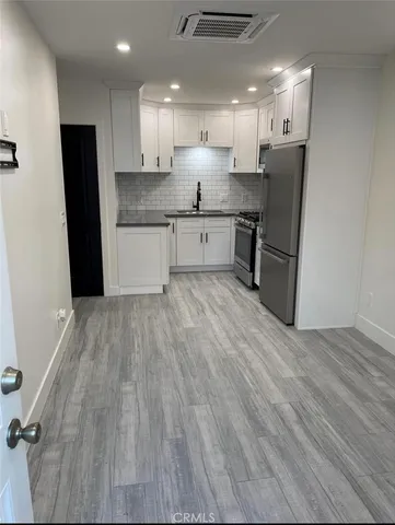 a kitchen with stainless steel appliances granite countertop a refrigerator sink and wooden floor