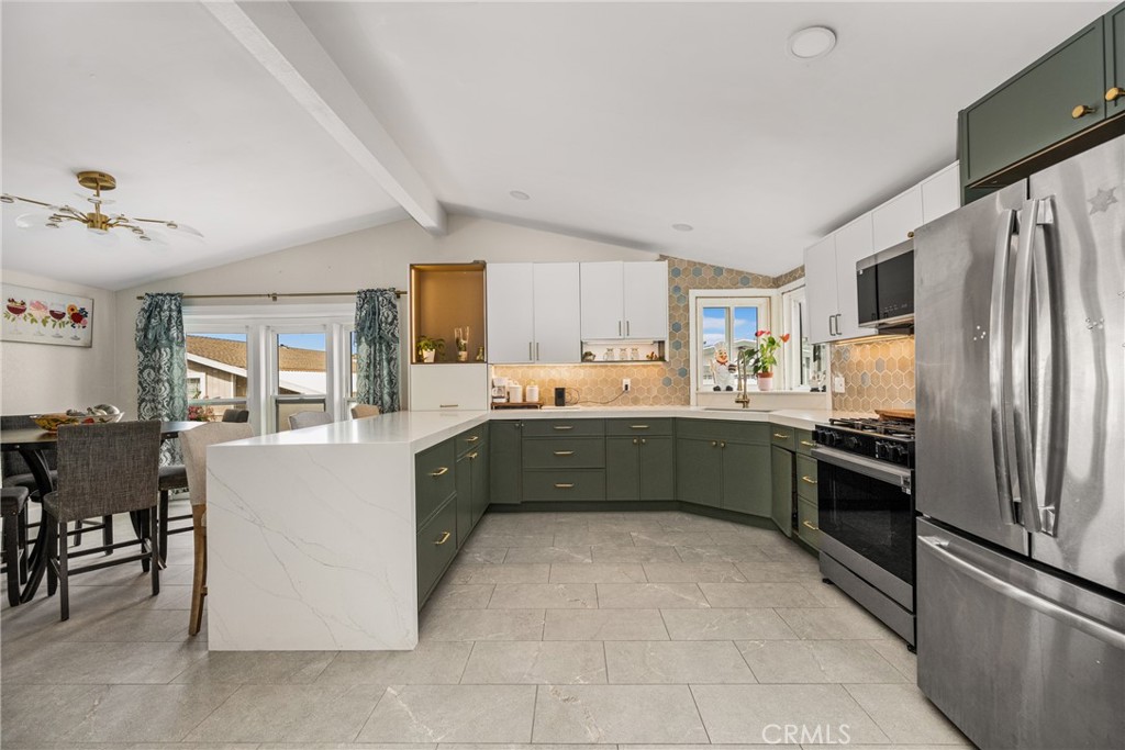 23301 Ridge Rte Drive, Unit 56 Laguna Hills, CA 92653 - Photo 14 of 44 a kitchen with stainless steel appliances granite countertop a refrigerator a stove top oven a sink dishwasher and a dining table with wooden floor
