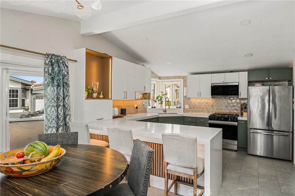 23301 Ridge Rte Drive, Unit 56 Laguna Hills, CA 92653 - Photo 18 of 44 a kitchen with granite countertop kitchen island stainless steel appliances a sink stove and refrigerator
