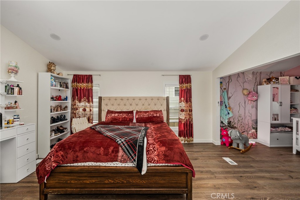 23301 Ridge Rte Drive, Unit 56 Laguna Hills, CA 92653 - Photo 26 of 44 a bedroom with a bed and a wooden floor