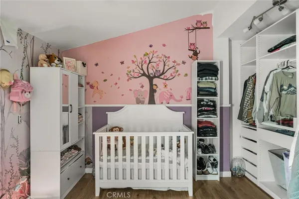a bedroom with a bed and flat tv screen on dresser