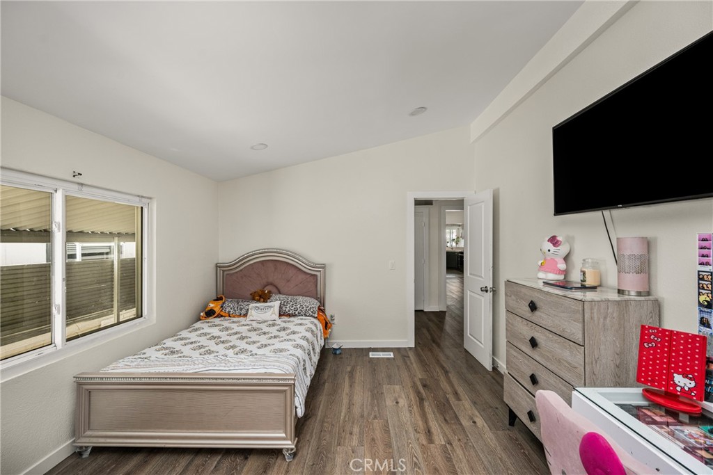 23301 Ridge Rte Drive, Unit 56 Laguna Hills, CA 92653 - Photo 28 of 44 a bedroom with a bed and flat tv screen on dresser