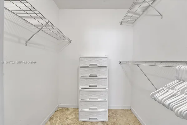 a view of walk in closet with empty racks