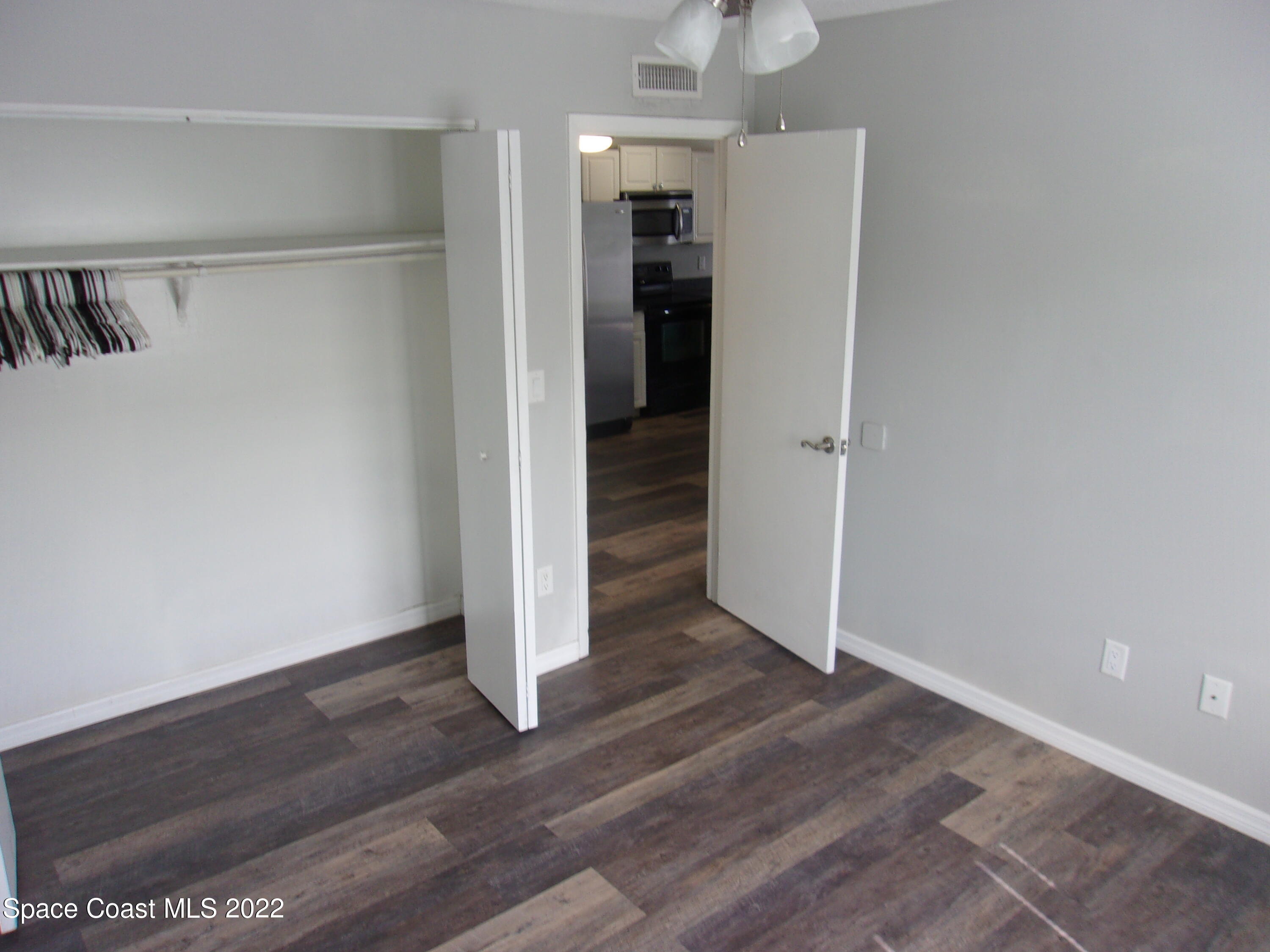 1050 North Fiske Boulevard, Unit 406 Cocoa, FL 32922 - Photo 8 of 11 an empty room with wooden floor