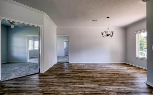 a view of a room with wooden floor exposed radiator and windows