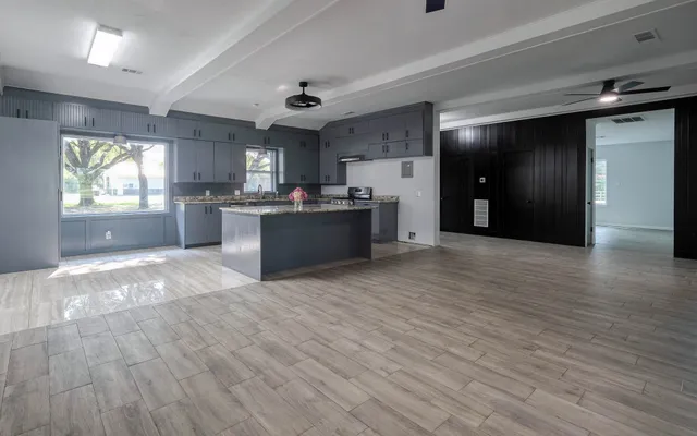 a large kitchen with stainless steel appliances granite countertop a refrigerator and a stove top oven