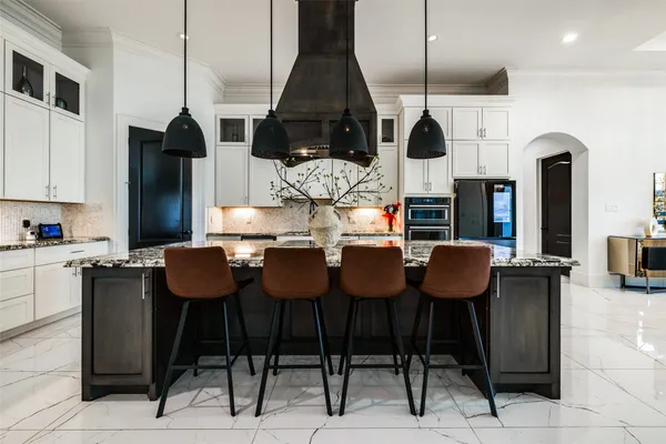 a kitchen with stainless steel appliances kitchen island granite countertop a table and chairs in it