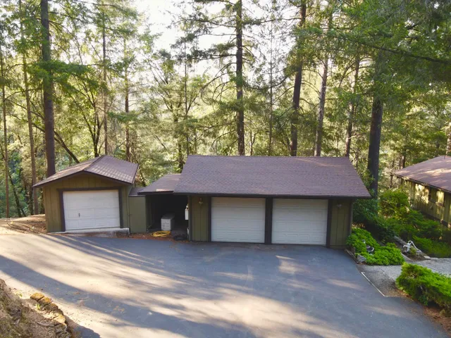 a front view of a house with a garden and trees