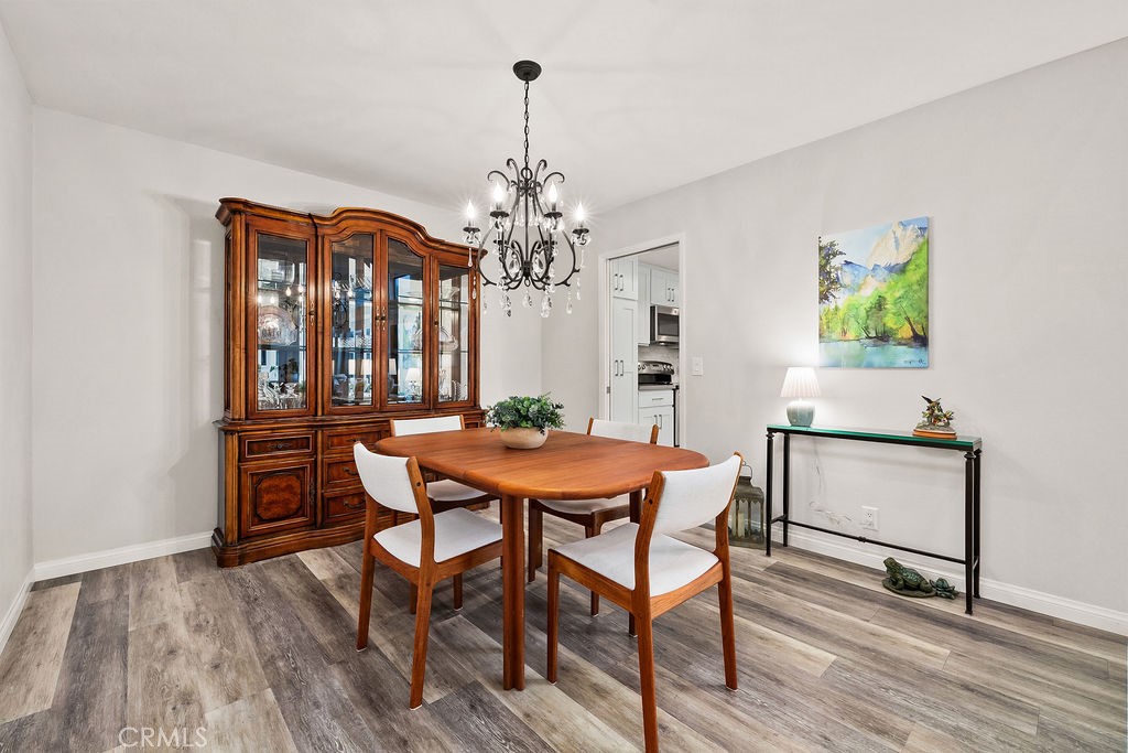 38 Navarre, Unit 138 Irvine, CA 92612 - Photo 13 of 33 a dining room with furniture a chandelier and wooden floor