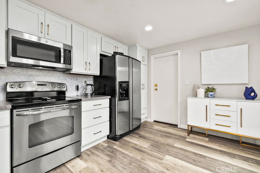 38 Navarre, Unit 138 Irvine, CA 92612 - Photo 18 of 33 a kitchen with white cabinets and stainless steel appliances