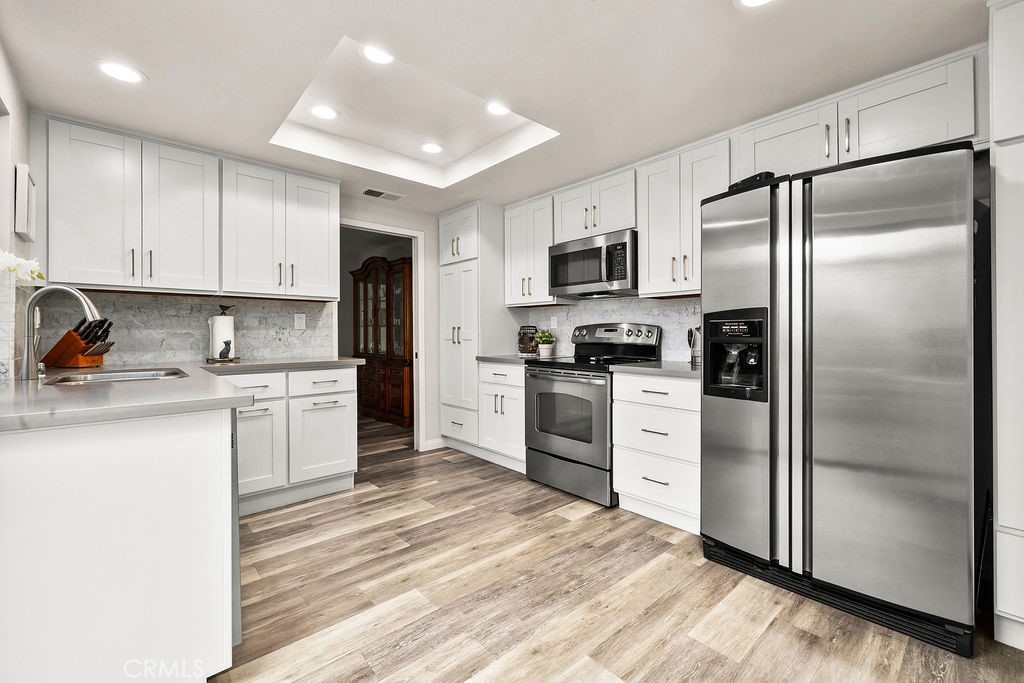 38 Navarre, Unit 138 Irvine, CA 92612 - Photo 19 of 33 a kitchen with white cabinets stainless steel appliances and refrigerator
