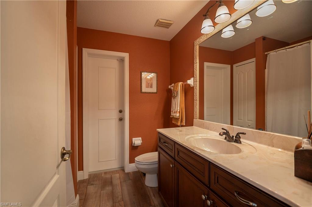1207 Imperial Drive Naples, FL 34110 - Photo 15 of 15 a bathroom with a granite countertop sink a toilet and shower