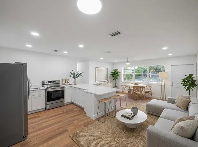 a living room with furniture kitchen and a large window