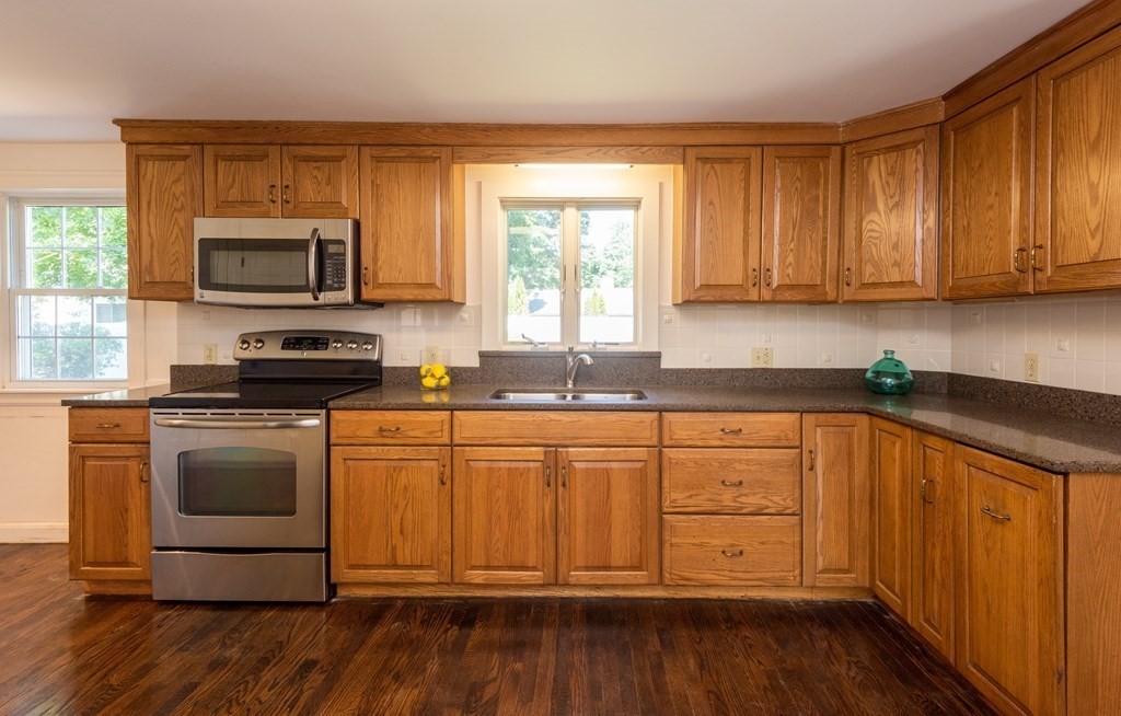 81 Fairview Avenue Lynnfield, MA 01940 - Photo 20 of 41 a kitchen with granite countertop wooden cabinets a sink and a stove with wooden floor