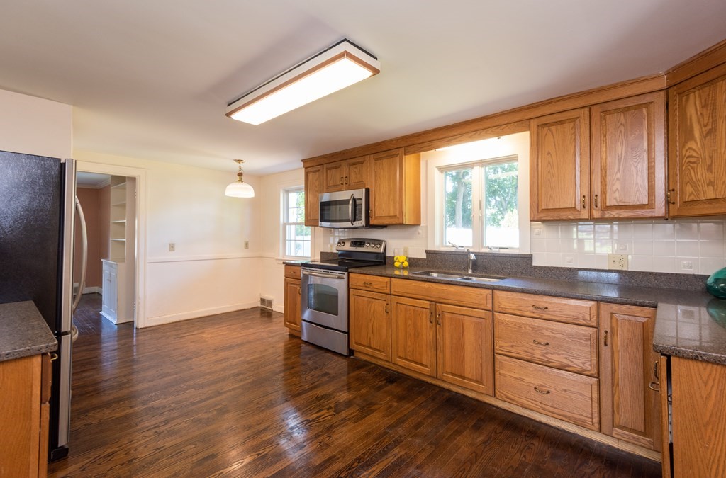 81 Fairview Avenue Lynnfield, MA 01940 - Photo 23 of 41 a kitchen with stainless steel appliances granite countertop a stove top oven a refrigerator a sink and dishwasher with wooden floor