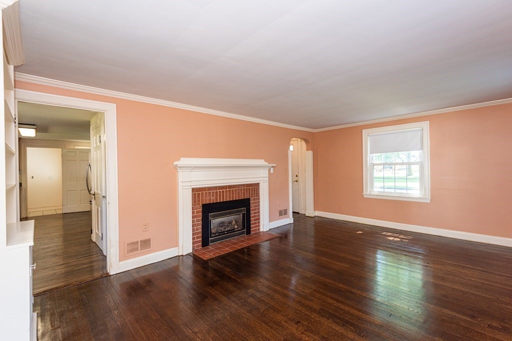 81 Fairview Avenue Lynnfield, MA 01940 - Photo 6 of 41 an empty room with wooden floor fireplace and windows