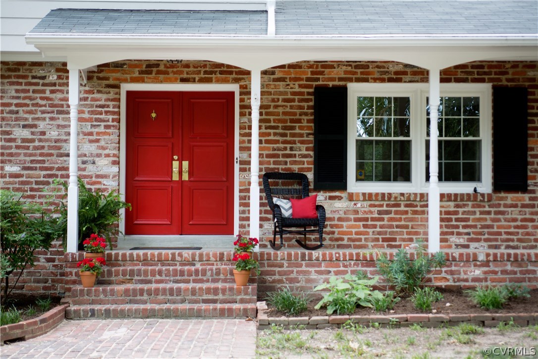 10301 Apache Road Richmond, VA 23235 - Photo 2 of 24 front view of a brick building with a bench in front of a house