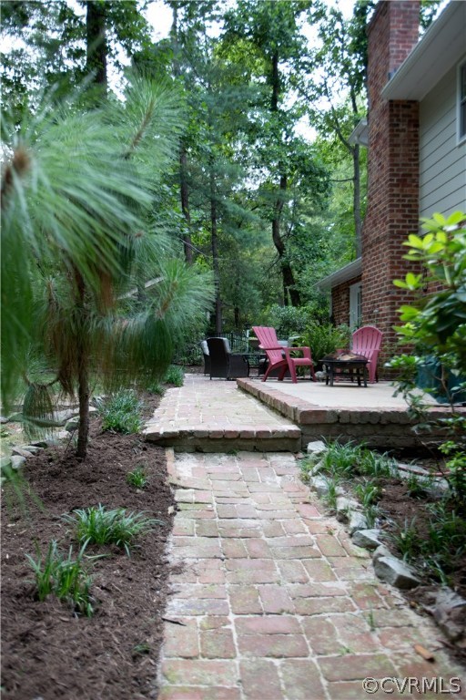 10301 Apache Road Richmond, VA 23235 - Photo 23 of 24 a view of a backyard with table and chairs plants and large trees