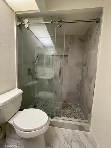 a bathroom with a toilet and a shower