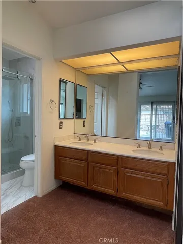 a spacious bathroom with a double vanity sink a toilet and a shower
