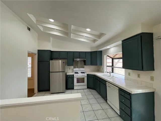 a kitchen with a stove a refrigerator and a more cabinets