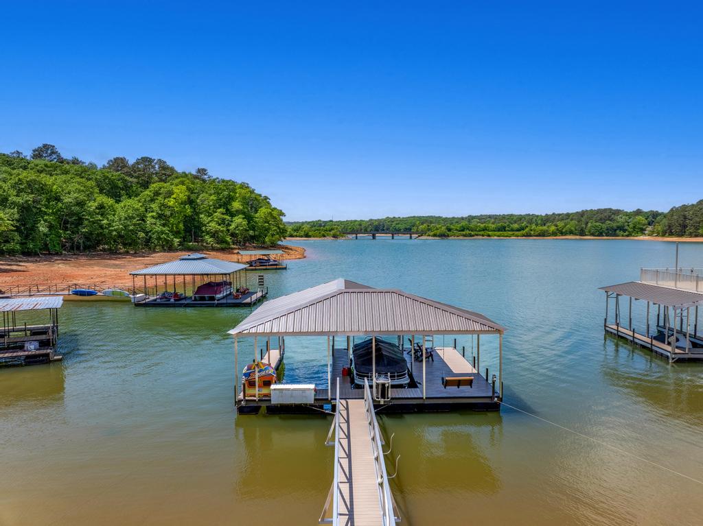 707 Vickery Street Extension Hartwell, GA 30643 - Photo 47 of 50 A tranquil lake view features multiple boat docks and lush green surroundings under a clear blue sky.
