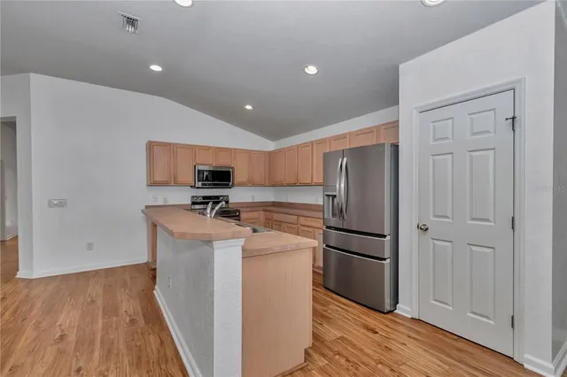 a kitchen with stainless steel appliances granite countertop a refrigerator and a stove top oven