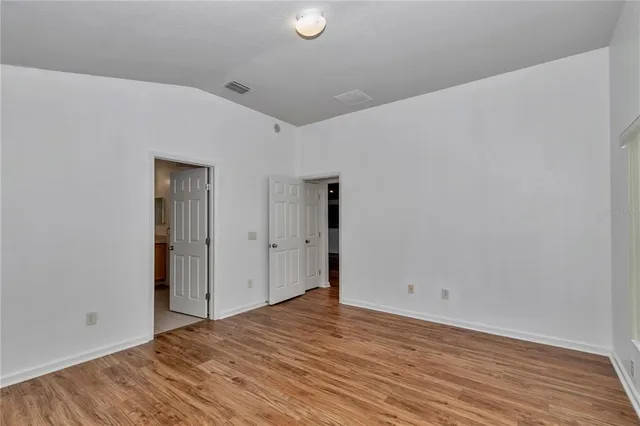 a view of empty room with wooden floor
