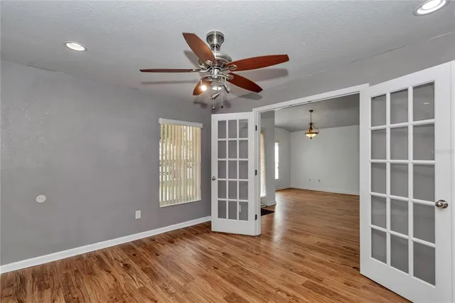 a view of an empty room with a window and wooden floor