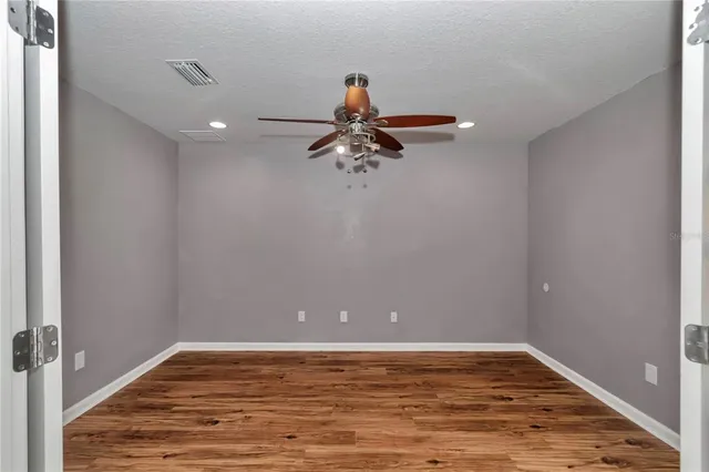 a view of a room with wooden floor and fan