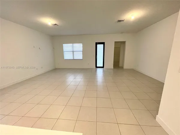 an empty room with white walls and tiles