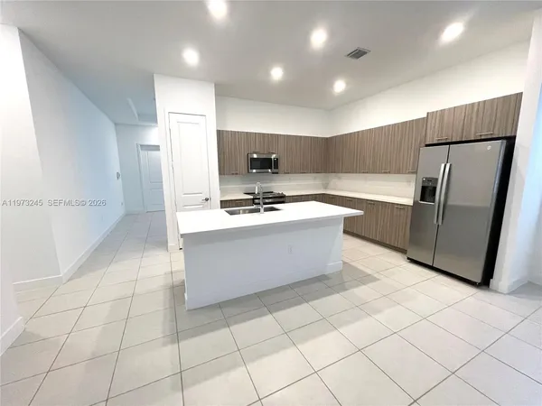 a kitchen with stainless steel appliances a refrigerator sink and cabinets