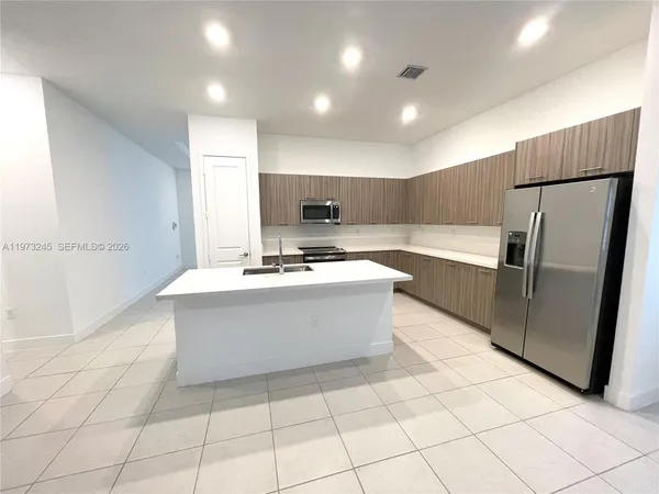 a kitchen with stainless steel appliances a refrigerator sink and microwave
