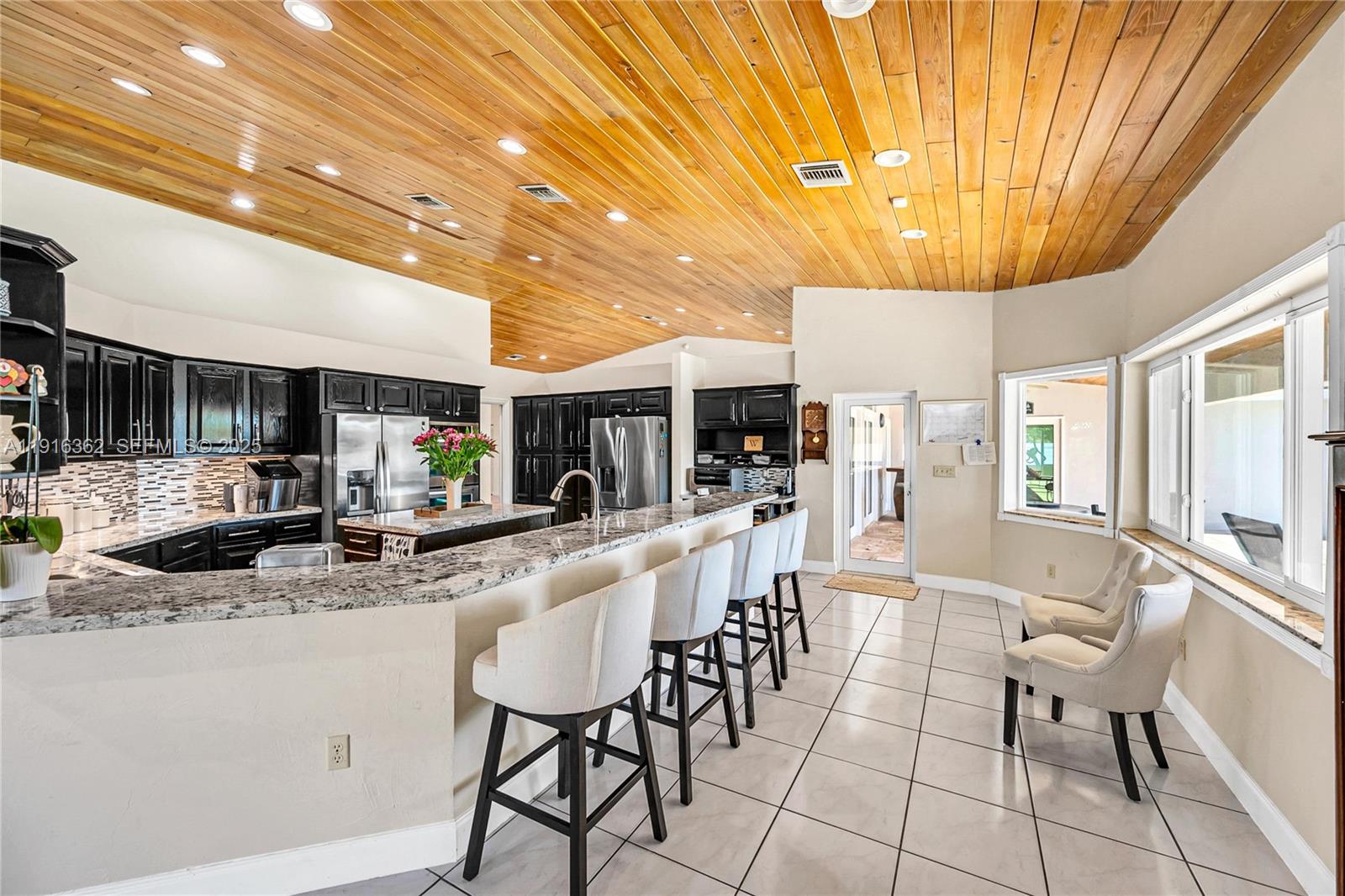10700 Southwest 139th Road Miami, FL 33176 - Photo 29 of 68 a large white kitchen with a large window and stainless steel appliances