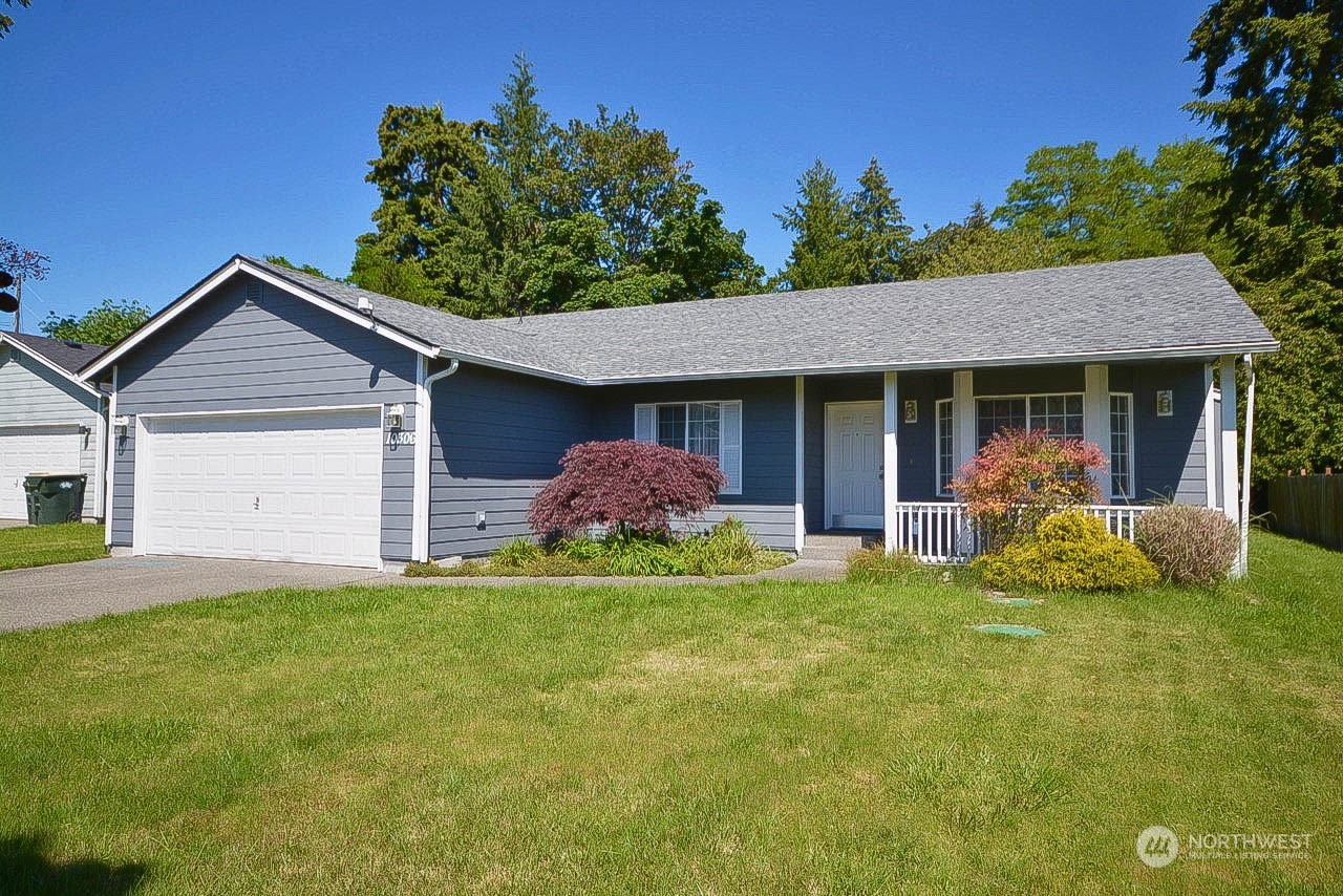 10306 3rd Street Southeast Yelm, WA 98597 - Photo 1 of 21 a front view of a house with a garden and trees