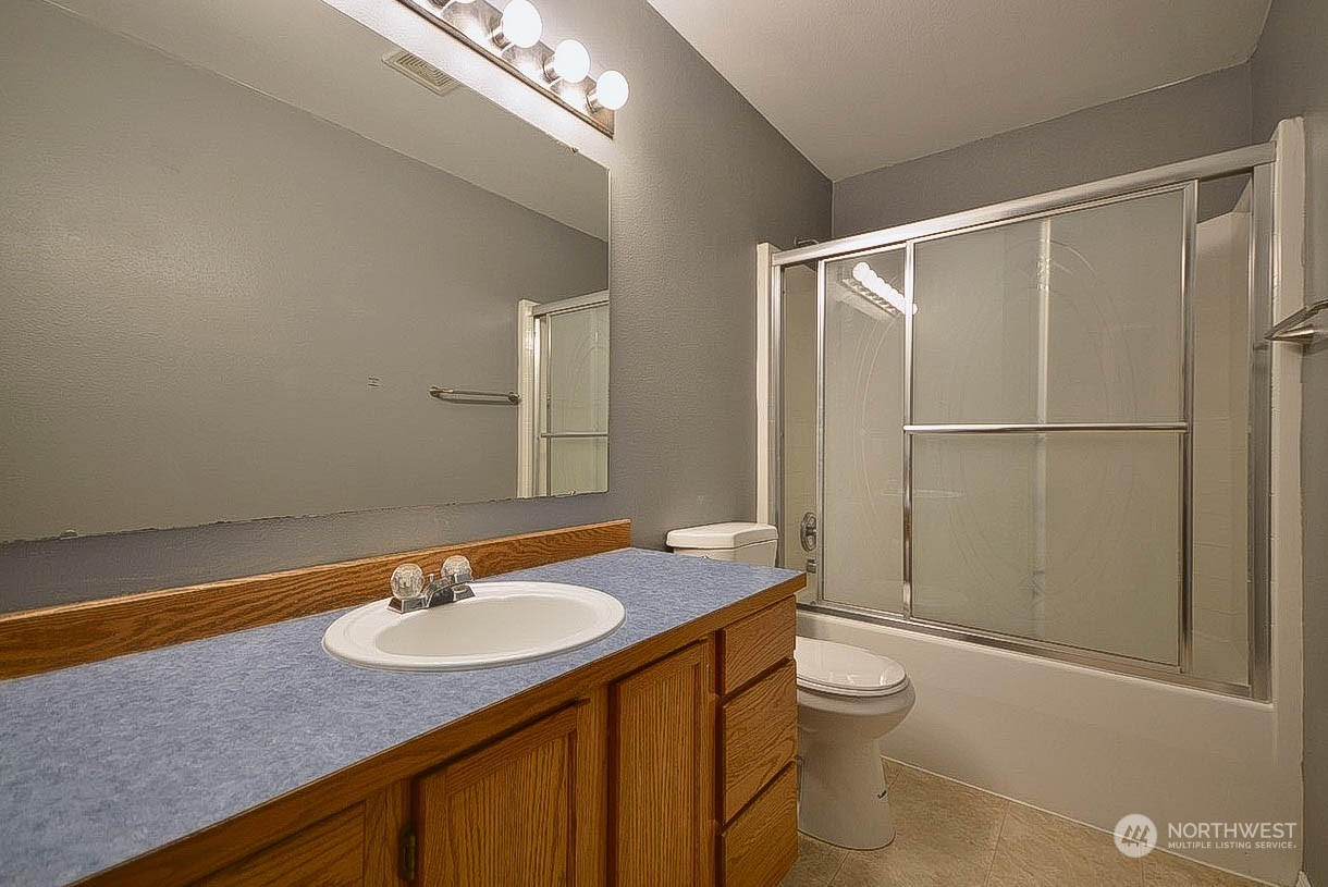 10306 3rd Street Southeast Yelm, WA 98597 - Photo 15 of 21 a bathroom with a granite countertop sink toilet and shower