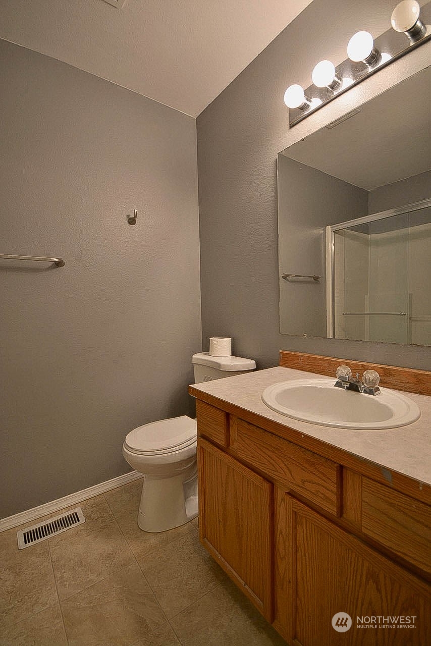 10306 3rd Street Southeast Yelm, WA 98597 - Photo 16 of 21 a bathroom with a granite countertop sink a toilet and a mirror