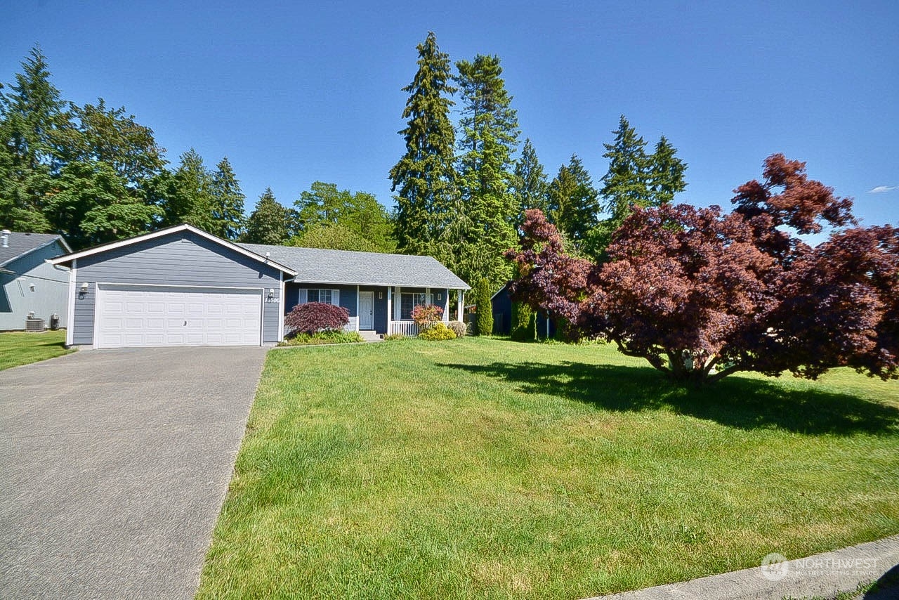 10306 3rd Street Southeast Yelm, WA 98597 - Photo 2 of 21 a front view of a house with a yard and garage