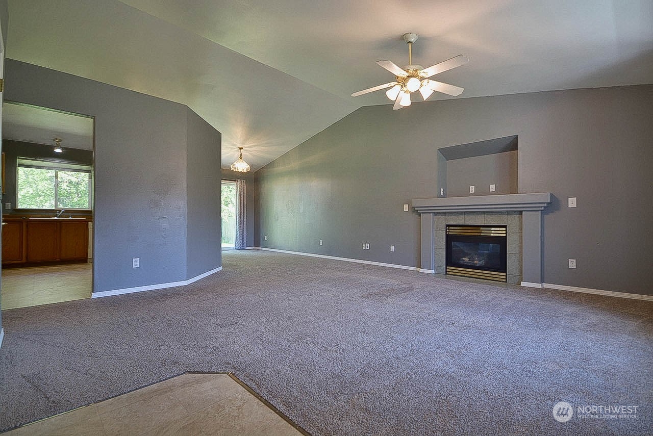 10306 3rd Street Southeast Yelm, WA 98597 - Photo 6 of 21 a view of an empty room with chandelier fan and fire place