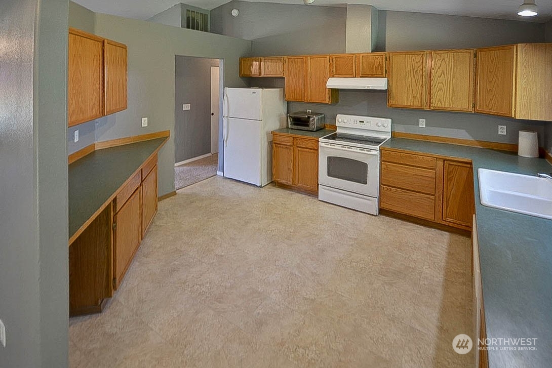 10306 3rd Street Southeast Yelm, WA 98597 - Photo 9 of 21 a kitchen with a sink a stove top oven and refrigerator