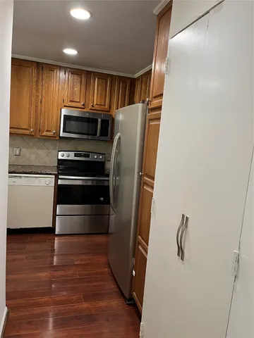 a kitchen with stainless steel appliances a refrigerator and a stove top oven