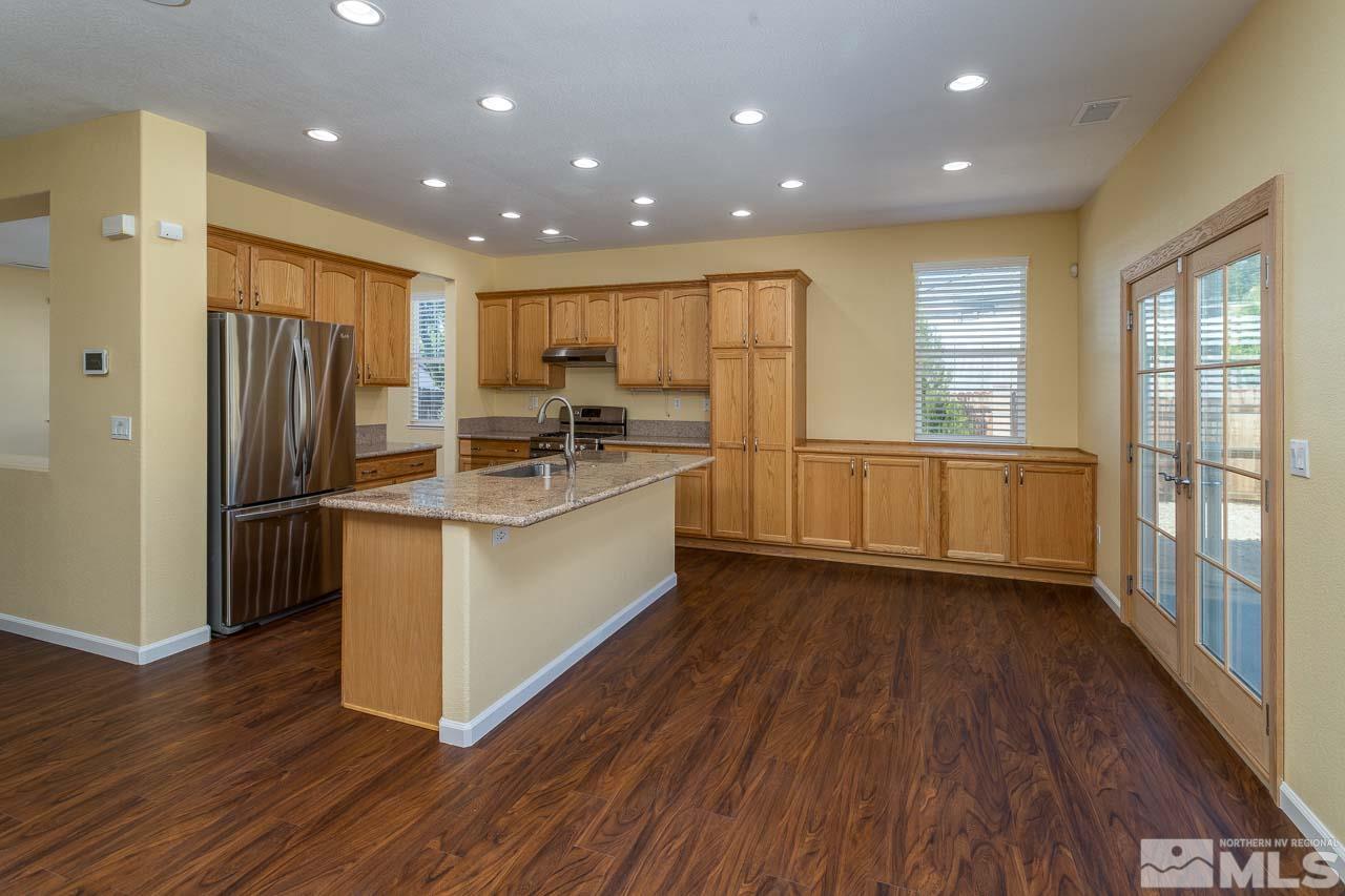 981 South University Reno, NV 89512 - Photo 6 of 19 a kitchen with stainless steel appliances granite countertop a refrigerator a sink dishwasher a stove and white countertops with wooden floor